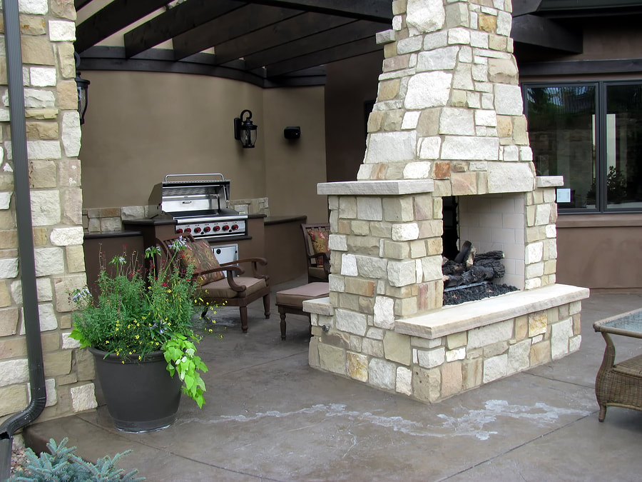 outdoor kitchen with stone fireplace